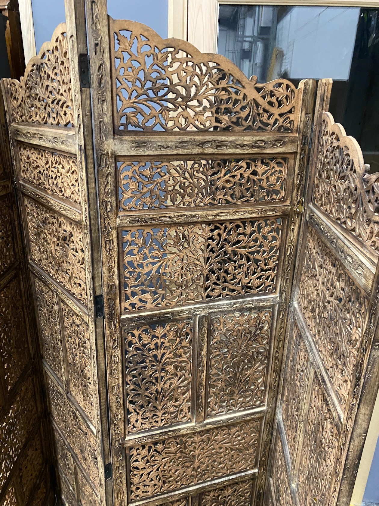 An Indian carved hardwood four fold screen, largest panel width 50cm, height 184cm